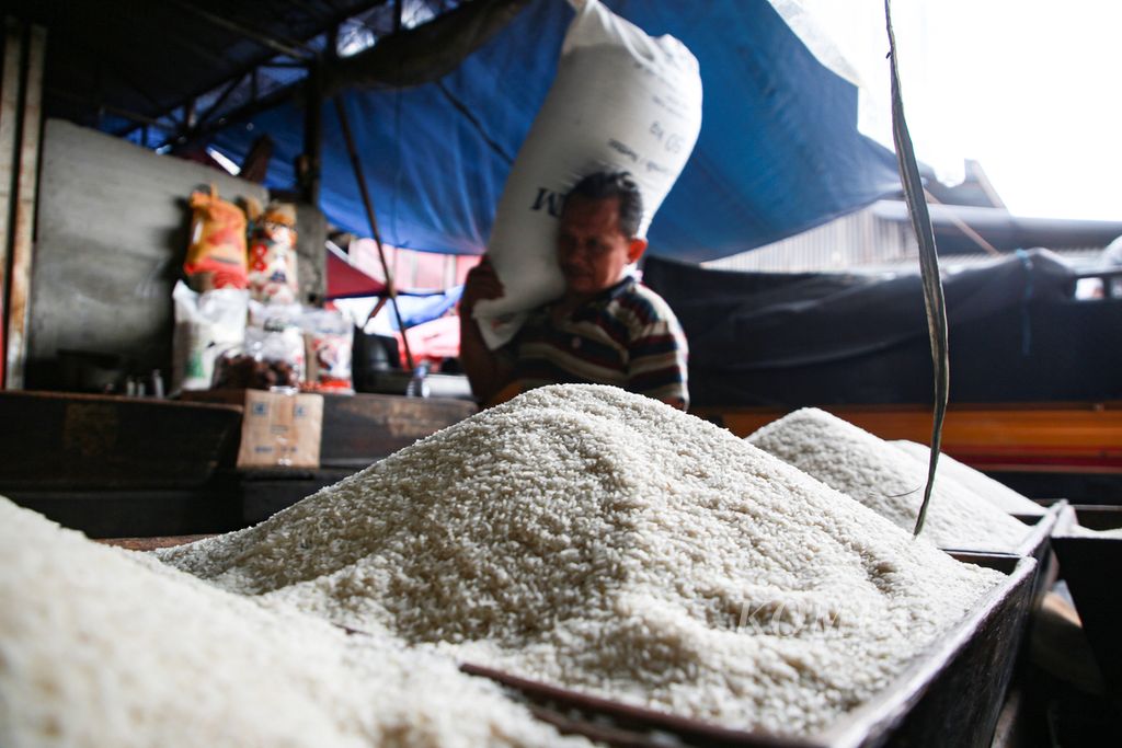 Pekerja memanggul karung berisi beras ke dalam gudang di toko Matahari di Pasar Kebayoran Lama, Jakarta Selatan, awal Januari 2023. Beras menjadi salah satu komoditas penyumbang inflasi bulan Desember 2022 sebesar 0,66 persen.