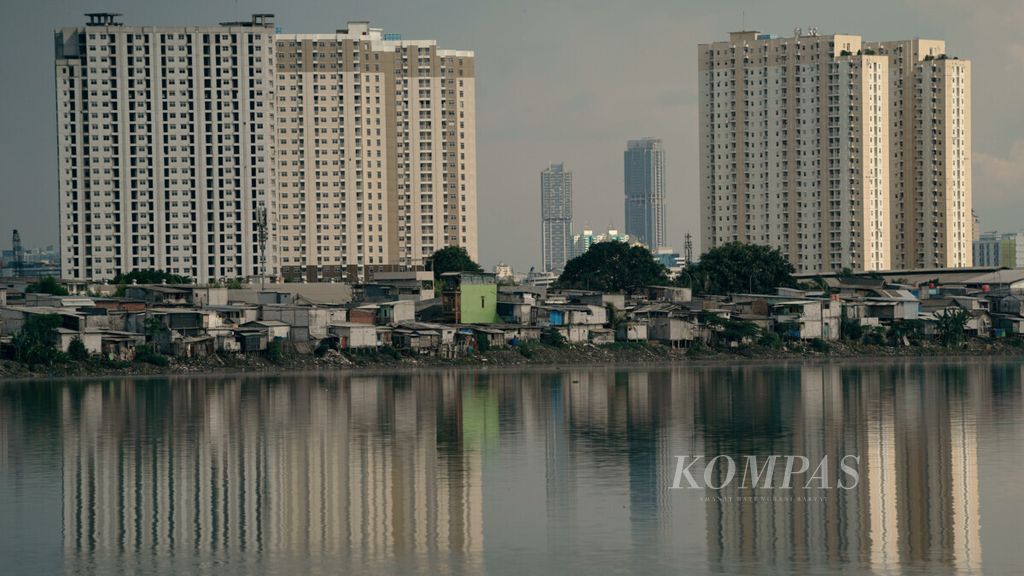 Hunian semipermanen berlatar belakang apartemen di Waduk Pluit, Jakarta Utara, Selasa (16/11/2021). Menurunnya kemampuan ekonomi rumah tangga akibat dampak Covid-19 telah menyebabkan perubahan pola konsumsi penduduk, terutama kelompok rentan atau miskin yang kurang beruntung dalam memenuhi kecukupan pangan. 