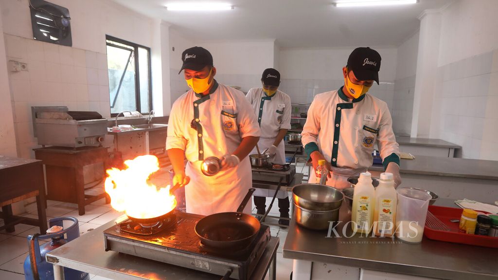 Siswa praktik memasak saat mengikuti mata pelajaran praktik kejuruan dalam pelaksanaan persiapan tatanan normal baru di SMK Jayawisata 2, Jakarta, Rabu (24/6/2020). Selain mengadakan kelas teori secara daring, pihak SMK pariwisata tersebut juga melakukan pembatasan kehadiran siswa ke sekolah untuk mata pelajaran praktik serta menerapkan protokol kesehatan, seperti cuci tangan, pengukuran suhu tubuh, penggunaan pelindung wajah, masker, sarung tangan, dan jarak fisik. 