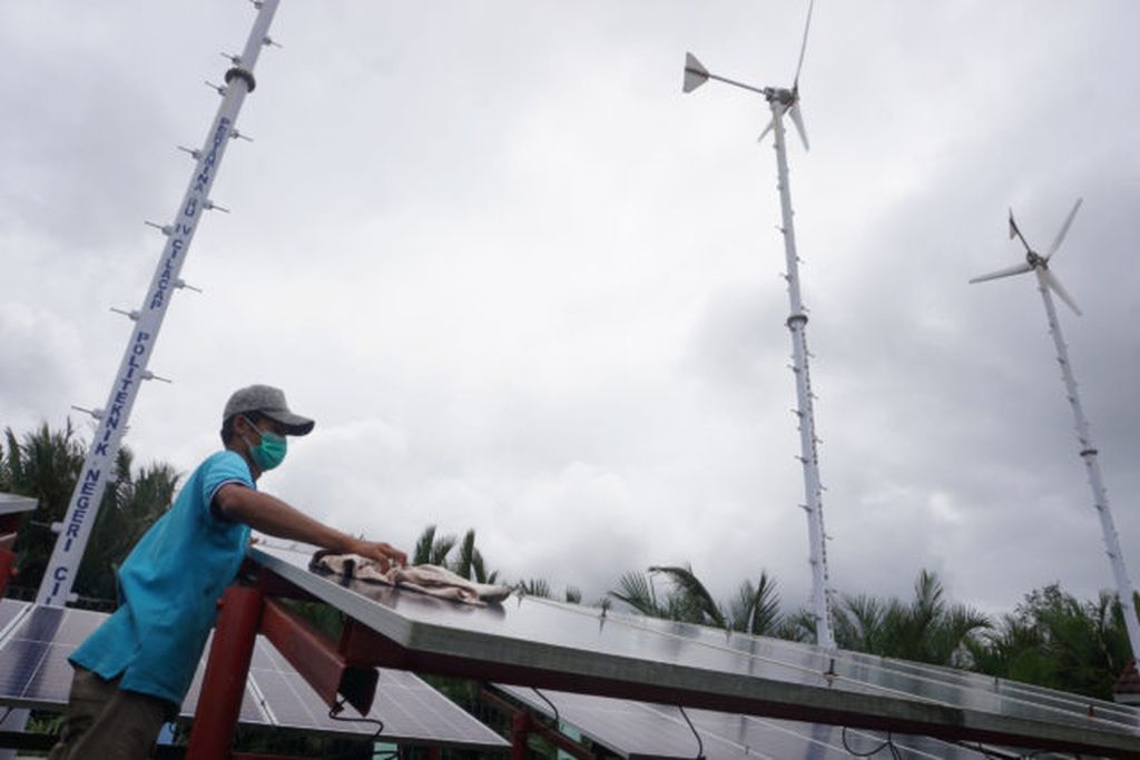 Petugas membersihkan panel surya di Dusun Bondan di Desa Ujung Alang, Kecamatan Kampung Laut, Kabupaten Cilacap, Jawa Tengah, Rabu (6/10/2021).