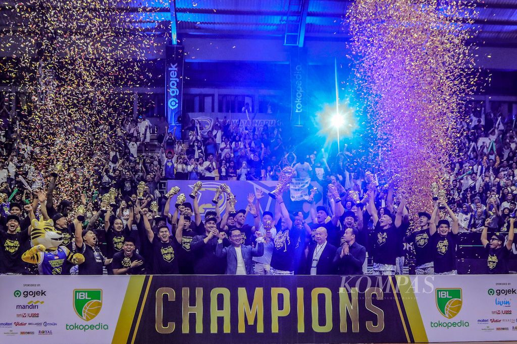 Para pemain dan tim ofisial Prawira Harum Bandung mengangkat trofi setelah menjadi juara Liga Bola Basket Indonesia atau IBL 2023 seusai mengalahkan Pelita Jaya Bakrie Jakarta, 63-58, pada gim kedua final di Arena C-tra, Bandung, Jawa Barat, Sabtu (22/7/2023). Hadir pula dalam perayaan gelar juara itu, Menteri Pemuda dan Olahraga Dito Ariotedjo serta Gubernur Jawa Barat Ridwan Kamil. Gelar juara itu mengakhiri 25 tahun penantian publik Jawa Barat, khususnya Bandung, akan gelar juara di liga bola basket Tanah Air.