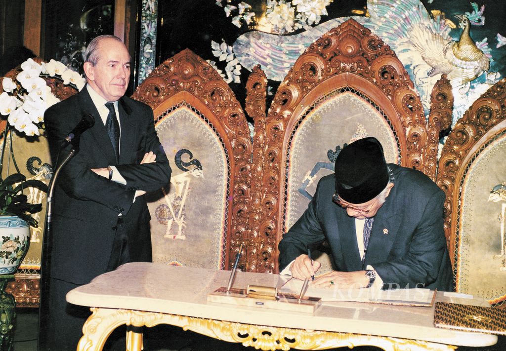 Managing Director of the International Monetary Fund (IMF) Michel Camdessus watches President Soeharto sign a memorandum of agreement on aid on Jalan Cendana, January 1998. This is one of the legendary photos taken by JB Suratno when he was a photojournalist for the daily <i>Kompas</i>.