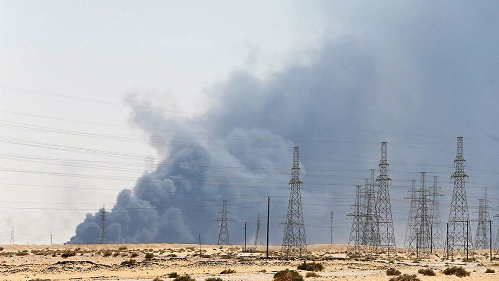 Asap tebal membubung tinggi ke udara seiring kebakaran besar yang diduga akibat serangan pesawat nirawak Houthi dukungan Iran atas instalasi minyak Aramco di Abqaiq, Arab Saudi, Sabtu (14/9/2019) pagi. Serangan itu mengganggu pasokan minyak global, menyebabkan harga minyak melonjak lebih dari 15 persen, Senin (16/9/2019), serta mengangkat mata uang negara eksportir minyak utama.