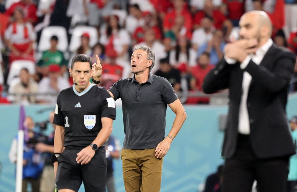 Pelatih Spanyol Luis Enrique (tengah) dan Pelatih Maroko Walid Regragui (kanan) memberikan instruksi kepada para pemain masing-masing dalam pertandingan babak 16 besar Piala Dunia Qatar di Stadion Education City di Al-Rayyan, Qatar, Selasa (6/12/2022).