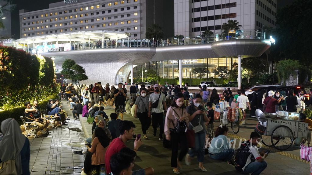 Residents' activities around the Hotel Indonesia roundabout, Central Jakarta, Friday (30/12/2022). The repeal of the rules for imposing restrictions on community activities still requires the community to implement health protocols.