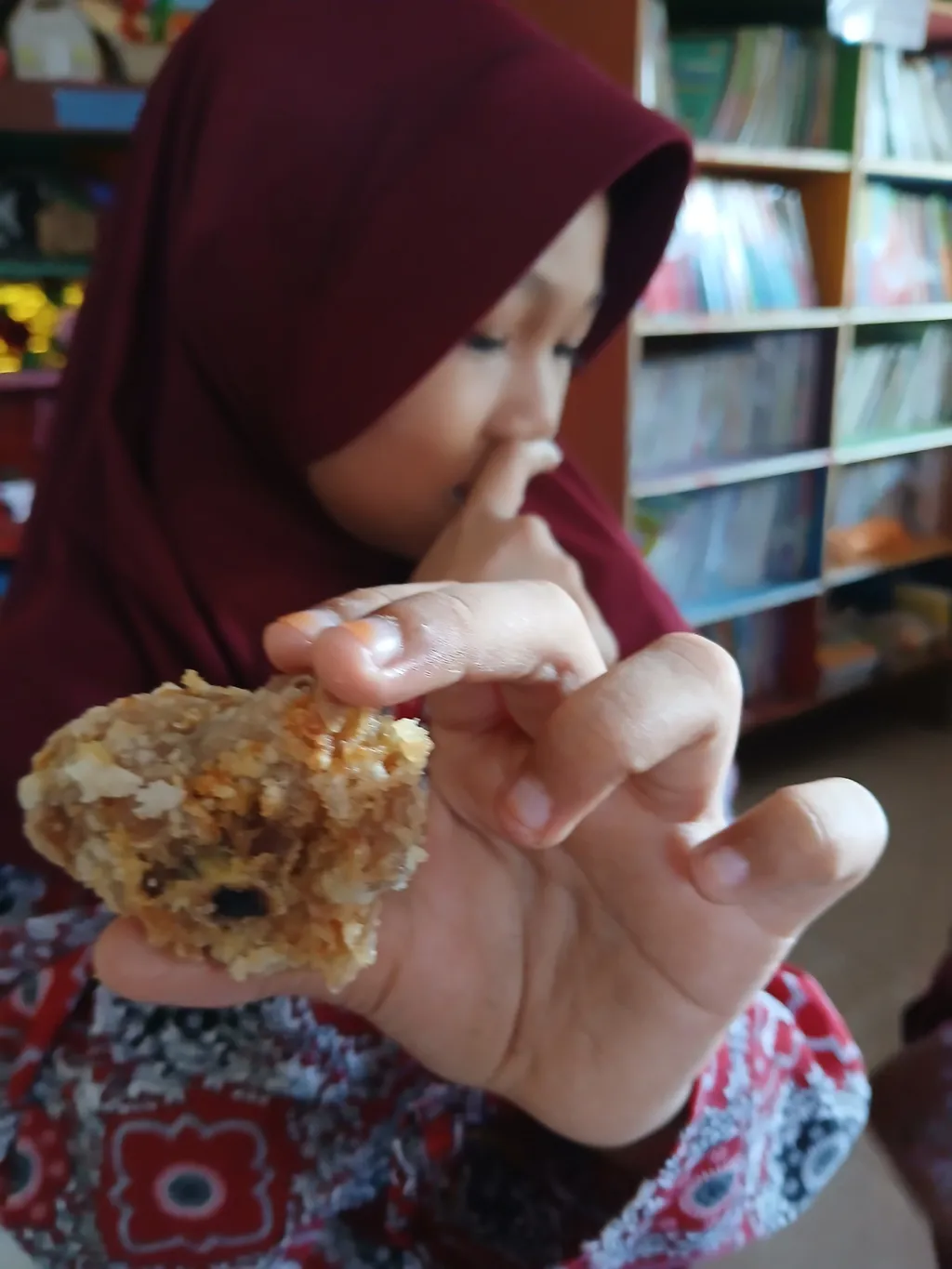 Siswa menunjukkan menu ayam yang berbau dan hitam dalam penyajian paket Makan Bergizi Gratis di Bombana, Sulawesi Tenggara, Rabu (23/4/2025). Belasan siswa keracunan. (GAMBAR: KOMPAS.ID)