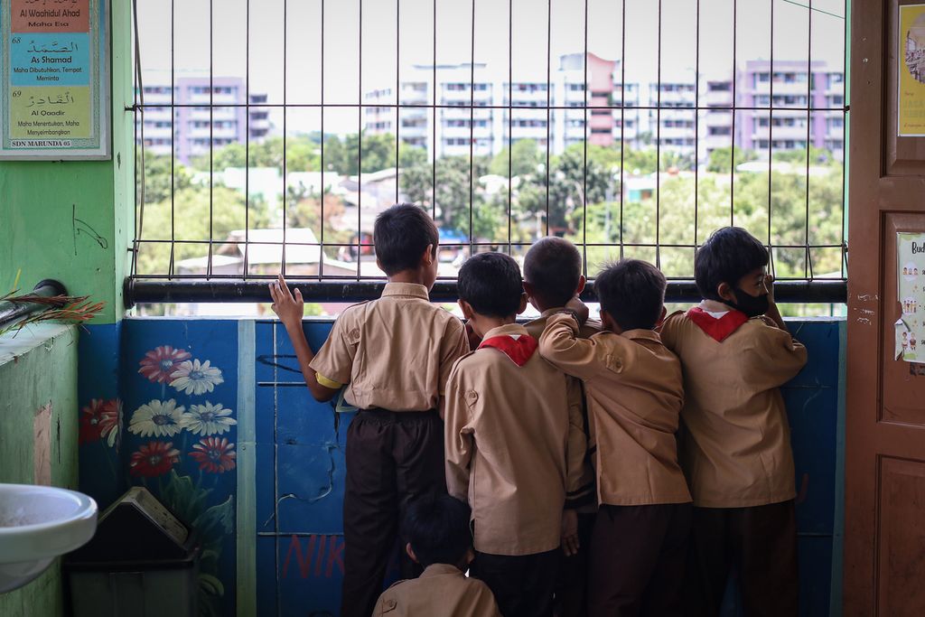 A number of students look outside the building at SD Negeri Marunda 05, Cilincing, North Jakarta, Wednesday (29/3/2023). Residents of Marunda Rusunawa still find coal dust in their neighborhood..
