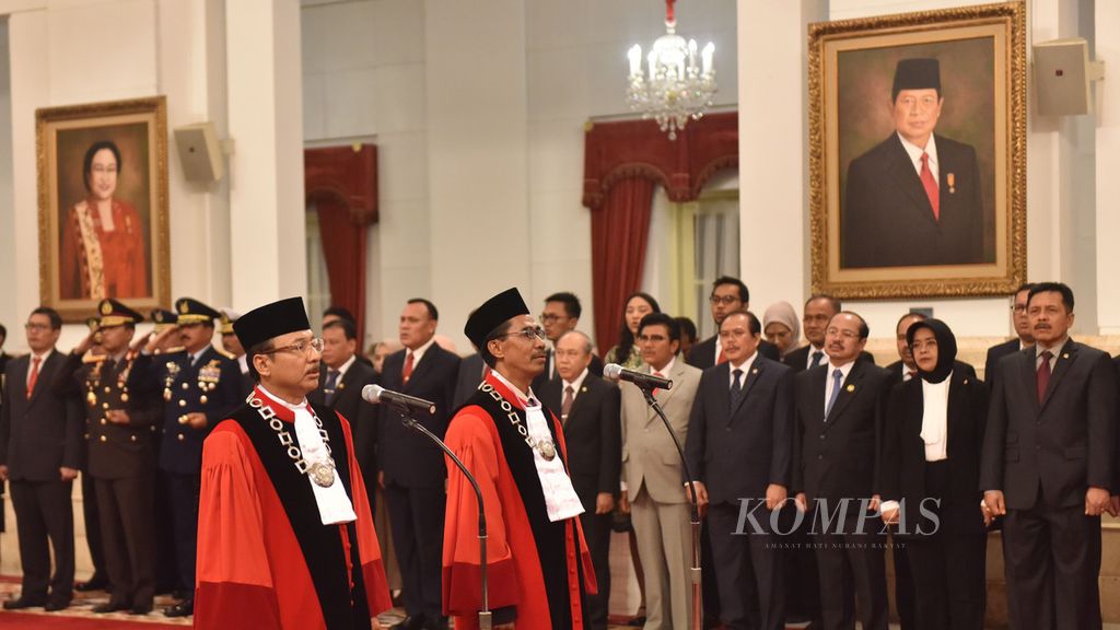Hakim Mahkamah Konstitusi (MK) Suhartoyo (kiri) dan Daniel Yusmic Pancastaki Foekh mengikuti upacara pengucapan sumpah hakim konstitusi dihadapan Presiden Joko Widodo di Istana Negara Jakarta, Selasa (7/1/2019). 