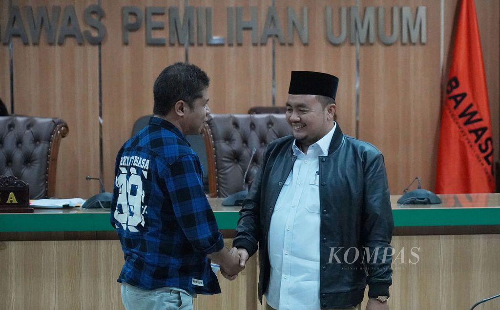 Sekertaris Jenderal DPP Partai Rakyat Adil dan Makmur (Prima) Dominggus Oktavianus Tobu Kiik (kiri) bersalaman dengan komisioner Komisi Pemilihan Umum, Mochammad Afifuddin (kanan), seusai Sidang Putusan Penanganan Dugaan Pelanggaran Administrasi Pemilu 2024 di ruang sidang Badan Pengawas Pemilihan Umum (Bawaslu), Jakarta, Senin (20/3/2023). 