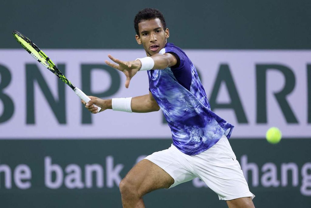 Petenis Kanada Felix Auger-Aliassime mengembalikan bola ke Tommy Paul dalam laga ATP Masters 1000 Indian Wells di Indian Wells, California, Selasa (14/3/2023). 