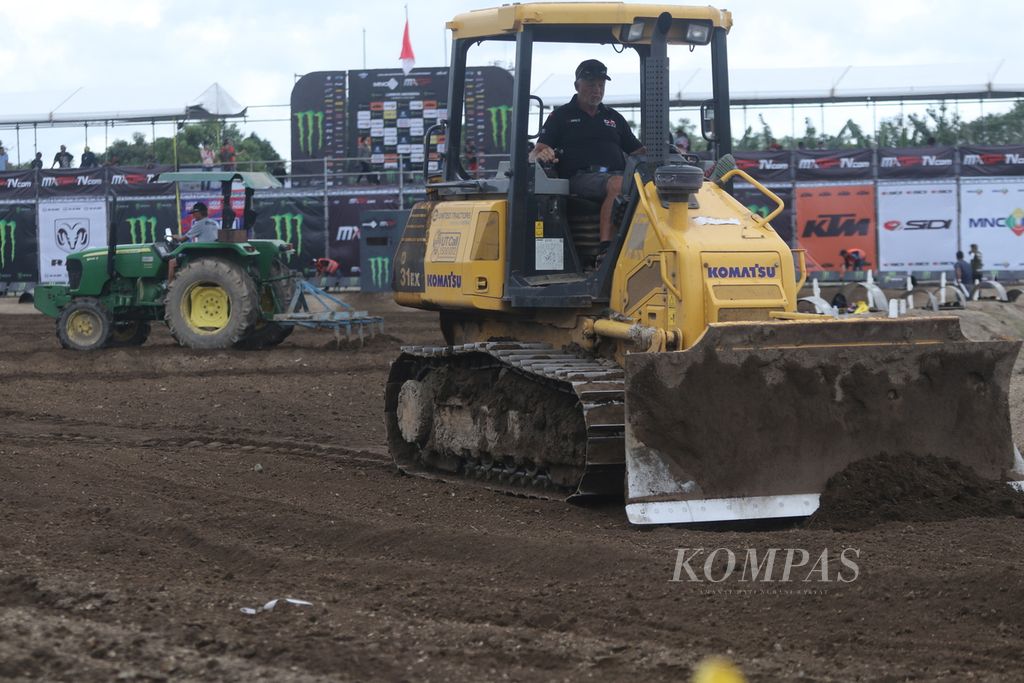 Desainer trek asal Selandia Baru, Greg Atkins, mengoperasikan alat berat untuk merapikan lintasan di depan garis start Sirkuit Selaparang, Mataram, NTB, menjelang sesi kualifikasi Kejuaraan Dunia Motokros MXGP seri Lombok, Sabtu (1/7/2023).