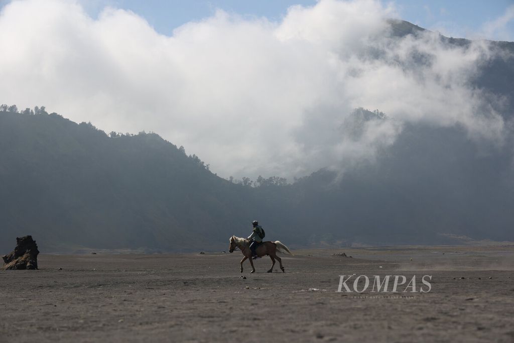 Warga lokal melintasi hamparan pasir dengan kudanya di kawasan Taman Nasional Bromo Tengger Semeru (TNBTS) di Kabupaten Probolinggo, Jawa Timur, Rabu (30/7/2025). 