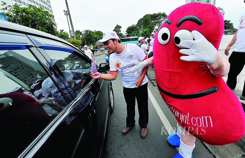 Aktivis dari Indonesia Kidney Care Club menggelar aksi memperingati Hari Ginjal Sedunia dengan membagikan stiker dan buku saku mengenai kesehatan ginjal kepada masyarakat yang melintas di kawasan Bundaran Hotel Indonesia, Jakarta, Kamis (8/3). 