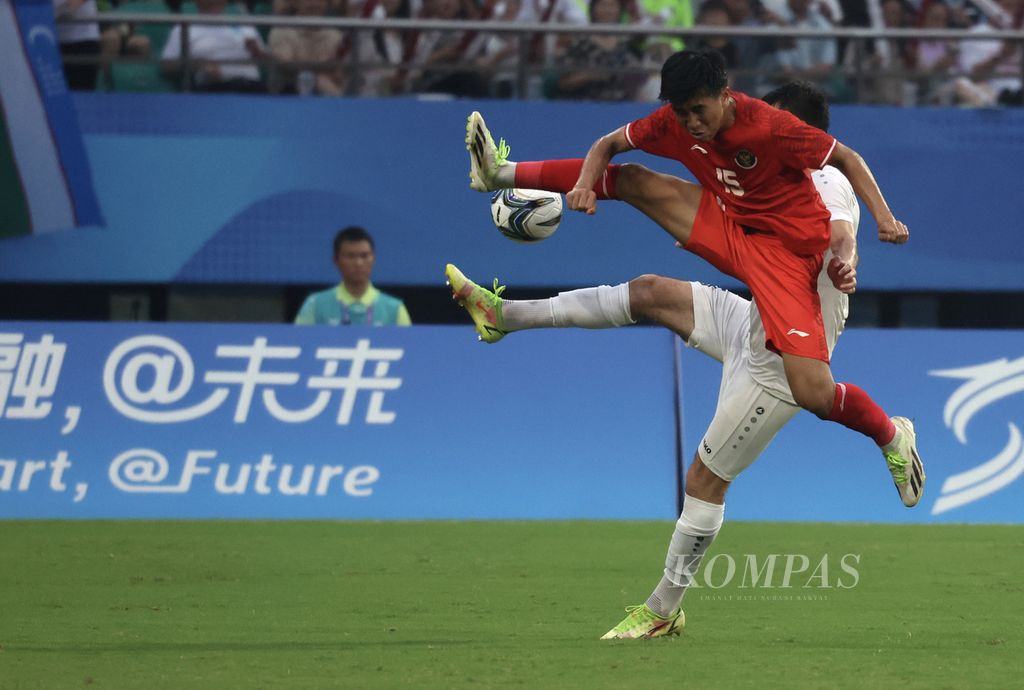 Indonesian U-24 midfielder, Muhammad Taufany Muslihudidin (front), is vying for the ball with Uzbekistan U-24 player, Mukhammadkodir Khamraliev, in a round of 16 football match at the 2022 Asian Games at the Shancheng Sports Centre Stadium in Hangzhou, China, on Thursday (28/9/2023).