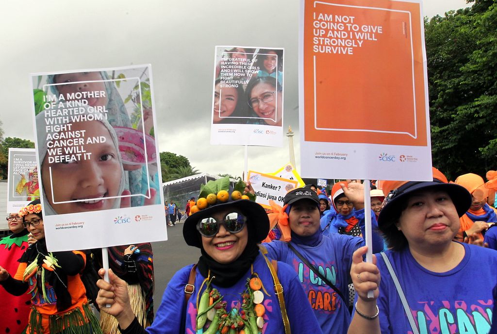 Peserta jalan sehat membawa poster dan berbusana unik saat mengikuti karnaval. Memperingati Hari Kanker Sedunia (HKS), PT Ferron Par Pharmaceuticals dan Indonesia Cancer Information and Support Center (CISC) menggelar acara jalan sehat Karnaval Penyintas Kanker di kawasan hari bebas kendaraan bermotor, Jalan MH, Thamrin, Jakarta, Minggu (23/2/2020).