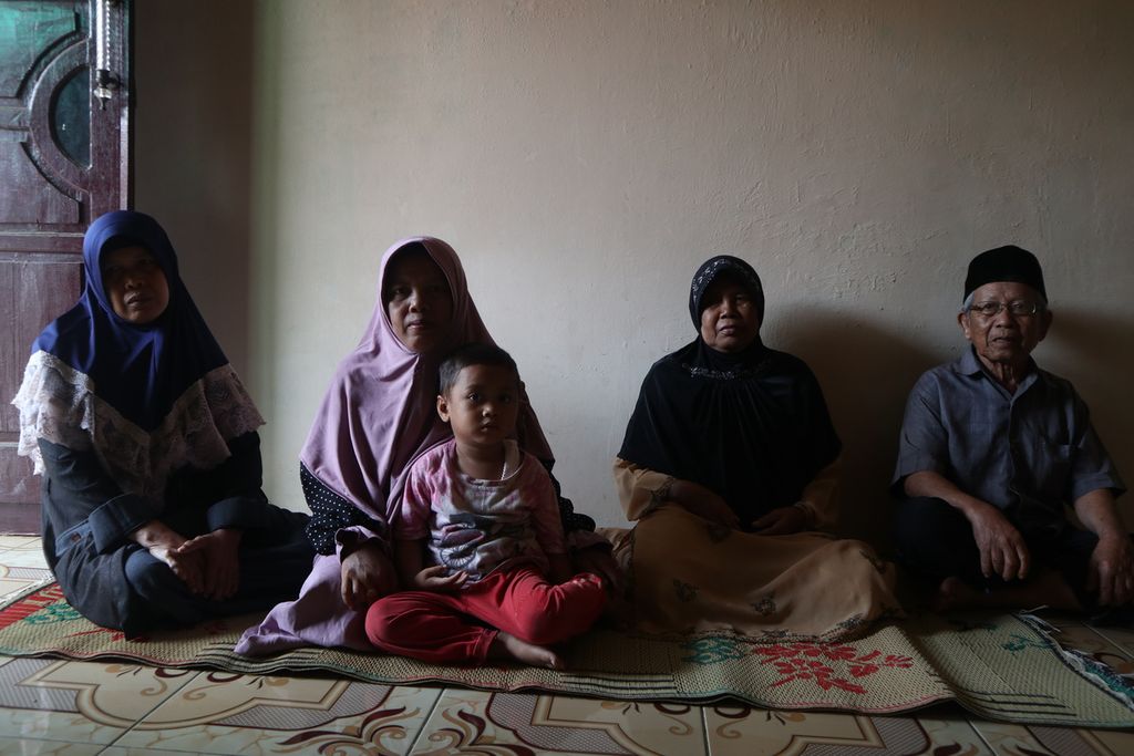 Carmi (kiri), mantan pekerja migran Indonesia, berfoto bersama keluarganya di Desa Rawaurip, Kecamatan Pangenan, Kabupaten Cirebon, Jawa Barat, Jumat (5/2/2021). Carmi bekerja di Arab Saudi selama 31 tahun dan putus kontak dengan keluarga. Setelah kembali ke Cirebon, Carmi harus beradaptasi lagi.