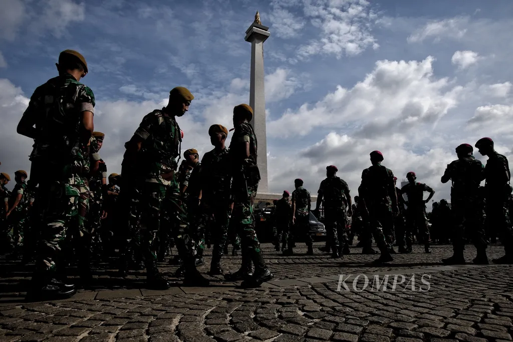 Tentara beristirahat seusai mengikuti apel gabungan Operasi Lilin Jaya 2024 di kawasan Monumen Nasional (Monas), Jakarta, Jumat (20/12/2024). Polda Metro Jaya bersama TNI menggelar apel gabungan dalam rangka operasi Lilin Jaya Pengamanan Natal 2024 dan Tahun Baru 2025. Polda Metro Jaya menyiapkan 4.771 pasukan gabungan pada 21 Desember sampai 2 Januari 2025 untuk menjaga ketertiban pada periode Natal 2024 dan Tahun Baru 2025 di Jakarta. Sementara itu, Polri melibatkan 141.605 personel gabungan serta mendirikan 2.794 posko yang terdiri atas pos pengamanan, pos pelayanan, dan pos terpadu. Operasi ini sebagai upaya untuk memberikan rasa aman dan nyaman bagi masyarakat yang akan menjalankan aktivitas, baik untuk ibadah, perjalanan mudik, dan rekreasi. Diprediksi pergerakan masyarakat saat periode Natal dan Tahun Baru mencapai 110,67 juta orang. Angka tersebut meningkat 2,83 persen atau sekitar 3,04 juta orang dari periode sebelumnya. KOMPAS/FAKHRI FADLURROHMAN (FAK) 20-12-2024