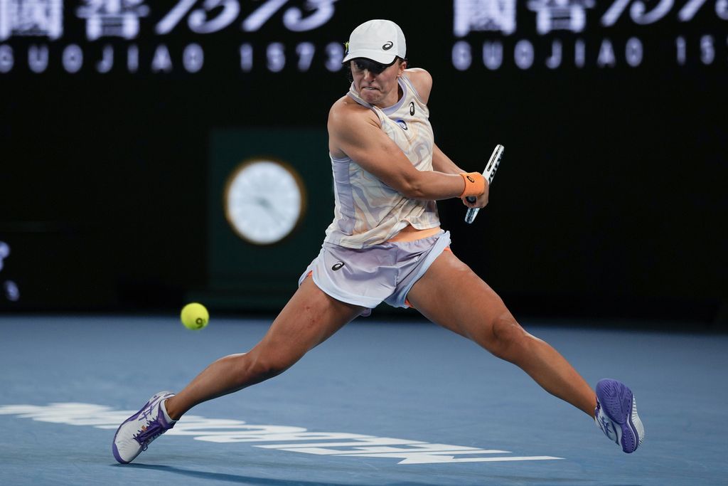 Petenis Polandia, Iga Swiatek, memukul bola saat melawan petenis Jerman, Jule Niemeier, pada laga babak pertama turnamen tenis Grand Slam Australia Terbuka di Melbourne Park, Senin (16/1/2023). Swiatek mengalahkan Niemeier, 6-4, 7-5.
