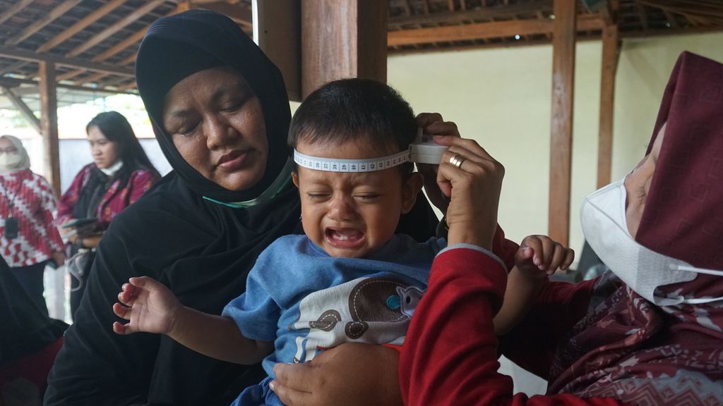 Seorang anak diukur lingkar kepalanya saat mendapatkan pelayanan di Posyandu Mawar Merah, Dusun Klangon, Sedayu, Bantul, DI Yogyakarta, Jumat (10/2/2023). Dalam pelayanan posyandu tersebut dilakukan pemantauan tumbuh kembang anak, pemberian vitamin A, serta pemberian makanan sehat dengan protein hewani pada setiap anak. Pelayanan ini guna mencegah dan menangani tengkes (<i>stunting</i>) secara lebih tepat.