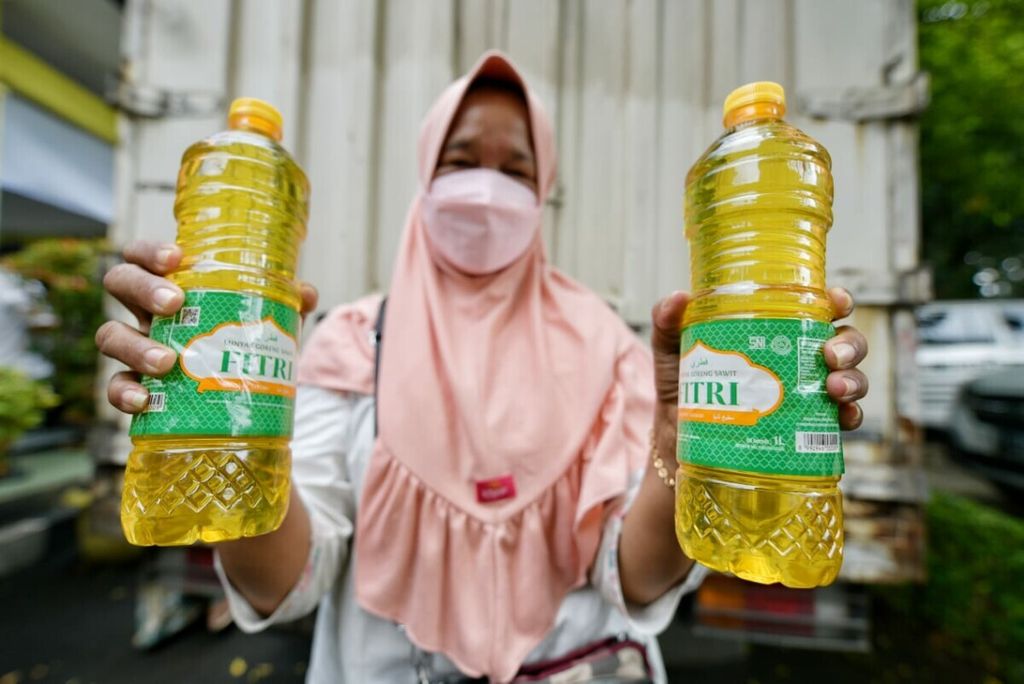 Warga memperlihatkan minyak goreng yang dibeli saat Pasar Murah Minyak Goreng di Kota Bekasi, Selasa (11/1/2022).