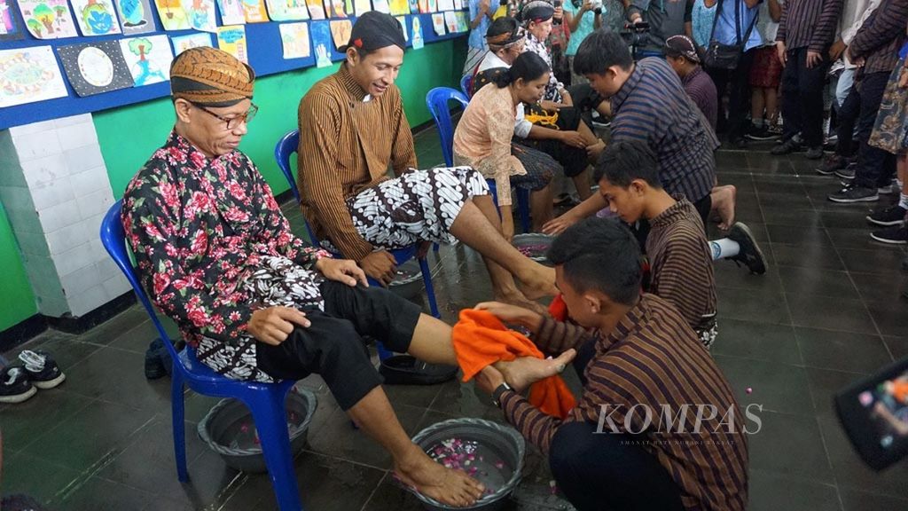 Murid membasuh kaki gurunya di SMP Pius, Cilacap, Jawa Tengah, Senin (25/11/2019).