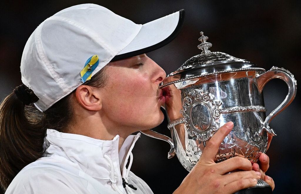 Petenis Polandia, Iga Swiatek, mencium trofi Suzanne Lenglen, lambang juara tunggal putri Perancis Terbuka, seusai mengalahkan petenis Amerika Serikat, Cori Coco Gauff, 6-1, 6-3, pada laga final Grand Slam Perancis Terbuka di Lapangan Philippe Chatrier, Roland Garros, Paris, Perancis, Sabtu (4/6/2022).