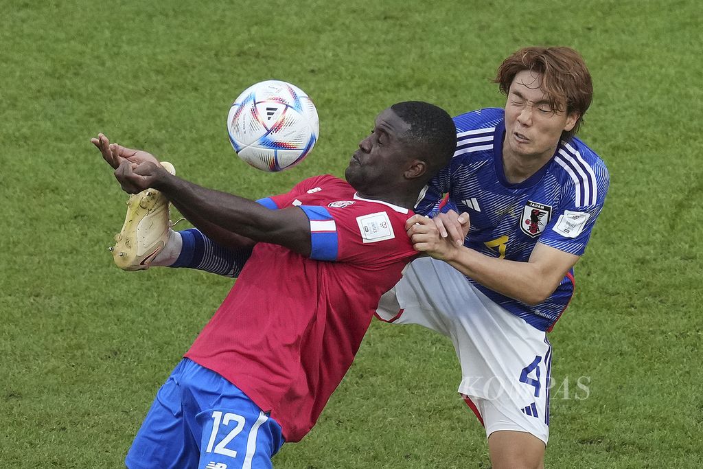 Pemain Jepang Kou Itamura (kanan) berebut bola dengan pemain Kosta Rika Joel Campbell di fase Grup E Piala Dunia 2022 di Stadion Ahmad Bin Ali, Qatar, Minggu (27/11/2022). Kosta Rika menang 1-0. 