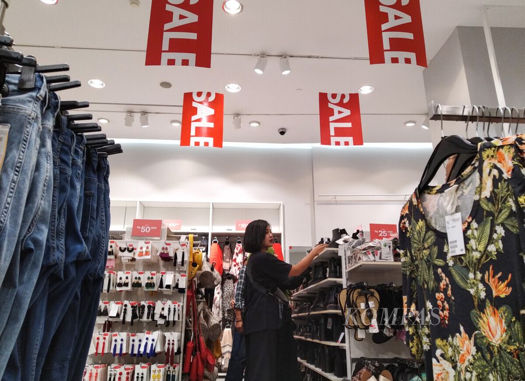 Pengunjung memilih produk alas kaki yang ditawarkan dengan potongan harga di gerai ritel pakaian di pusat perbelanjaan di kawasan Kebayoran Lama, Jakarta Selatan, Senin (3/6/2019). Momentum Lebaran yang berbarengan dengan Festival Jakarta Great Sale dimanfaatkan oleh pelaku usaha untuk meningkatkan penjualan. Potongan harga masih menjadi senjata utama untuk menarik minat belanja pengunjung. 