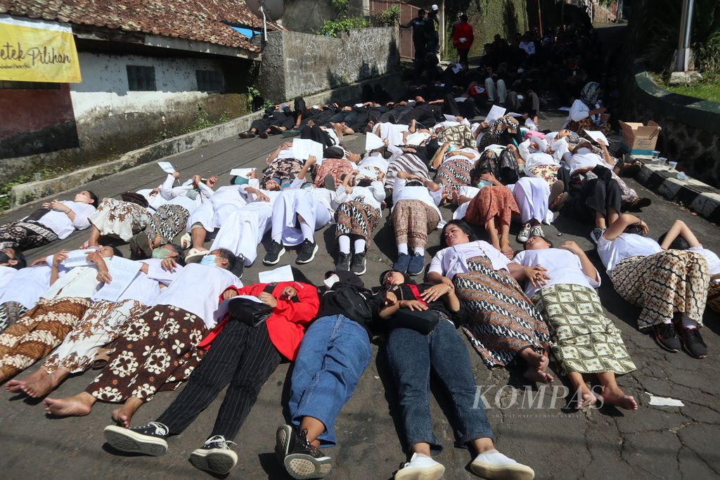 Masyarakat Adat Karuhun Urang Sunda Wiwitan berbaring di jalan saat aksi penolakan pencocokan dan sita eksekusi tanah di Blok Mayasih, Kelurahan Cigugur, Kabupaten Kuningan, Jawa Barat, Rabu (18/5/2022). Masyarakat Akur Sunda Wiwitan menilai, tanah yang menjadi lokasi sengketa merupakan lahan adat, bukan milik pribadi.