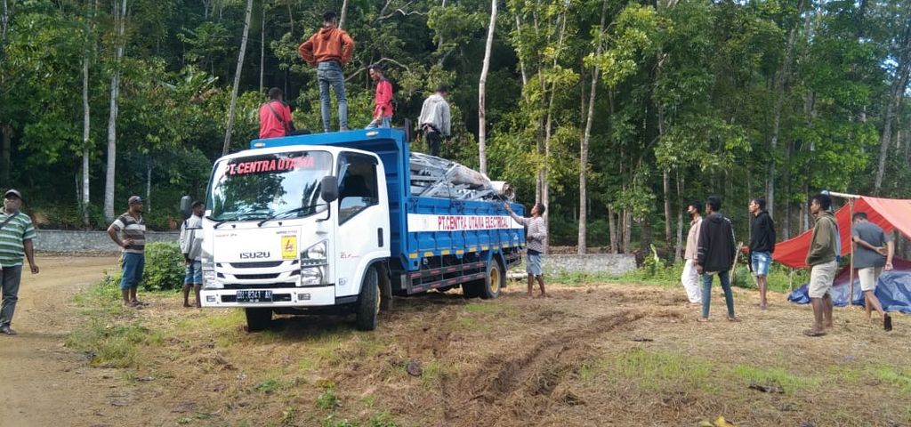 Sebuah truk mengangkut sarana dan prasarana listrik melintasi jalan terjal, bebatuan, dan bahkan melewati hutan menuju Desa Benteng Tawa 1 Kabupaten Nagekeo, NTT, untuk melistriki desa terpencil di Ngada, Flores.