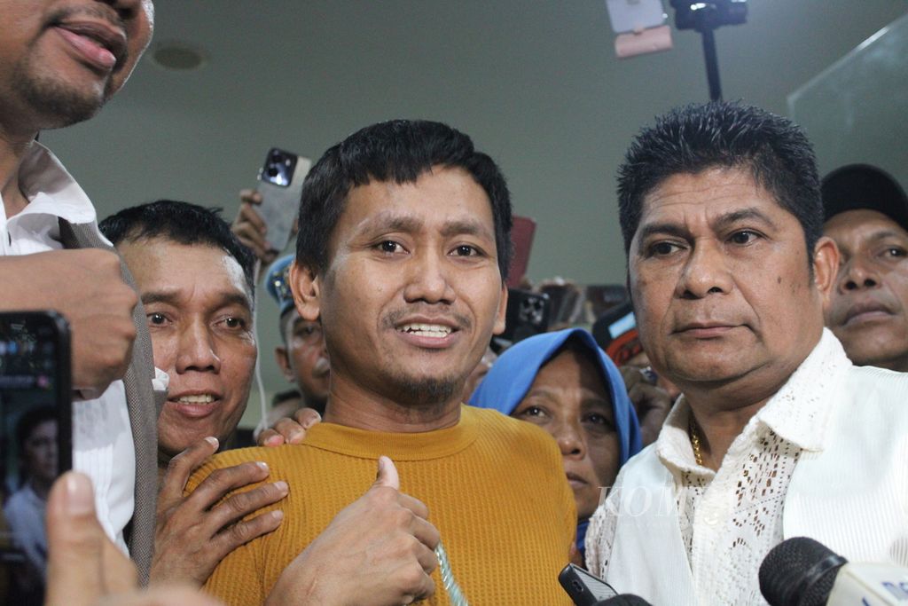 Pegi Setiawan (baju kuning) mengacungkan jempol saat keluar dari Direktorat Perawatan Tahanan dan Barang Bukti Kepolisian Daerah Jawa Barat, Kota Bandung, Senin (8/7/2024) malam sekitar pukul 22.00 WIB.  