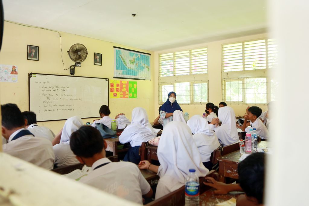 Guru Sekolah Menengah Pertama (SMP) Budaya, Dermiatin (45), memberikan penjelasan terkait mata pelajaran di SMP Budaya, Duren Sawit, Jakarta Timur, Selasa (22/11/2022). Ia telah mengajar di SMP Budaya sejak 10 tahun lalu. Ia adalah guru berstatus Prioritas 1. Sejak tahun 2021 ia telah lulus nilai minimal atau <i>passing grade</i> tetapi belum mendapat formasi. 