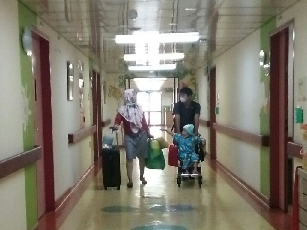 ILUSTRASI - Seorang anak pasien kanker didampingi kedua orangtuanya melintasi lorong ruang rawat inap perawatan anak di Rumah Sakit Kanker Dharmais, Jakarta Barat.