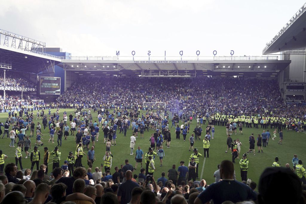 Pendukung Everton menyerbu lapangan setelah Everton memastikan tetap bertahan di Liga Primer menyusul kemenangan 1-0 atas Bournemouth pada laga pekan terakhir Liga Inggris di Stadion Goodison Park, Liverpool, Minggu (28/2023) tengah malam.