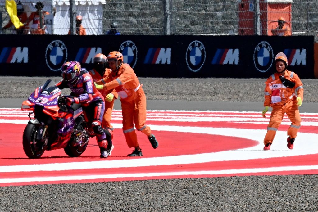 Pebalap Prima Pramac Racing Jorge Martin berusaha kembali ke sirkuit dibantu <i>marshal</i> setelah terjatuh saat balap sprint MotoGP seri Indonesia di Mandalika, Sabtu (28/9/2024). 