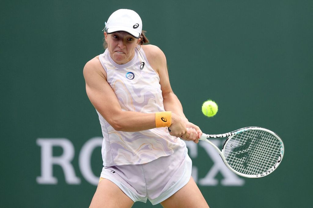 Petenis Polandia Iga Swiatek mengembalikan bola ke petenis AS Claire Liu pada babak kedua laga WTA 1000 Indian Wells di Indian Wells Tennis Garden, Sabtu (11/3/2023). Swiatek menang dengan skor 6-0, 6-1. 