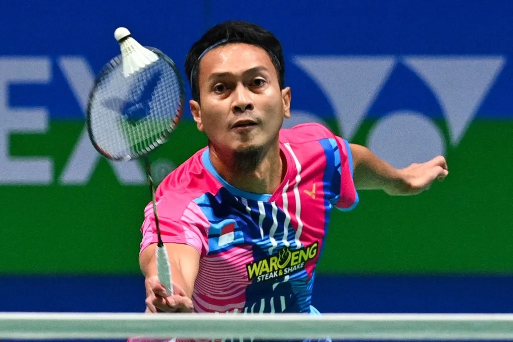 Pemain bulu tangkis Indonesia, Mohammad Ahsan, mengembalikan kok ke arah pasangan ganda Bagas Maulana/Muhammad Shohibul Fikri pada laga final All England, Minggu (20/3/2022). Ahsan lebih sering bermain di depan net karena kakinya cedera.