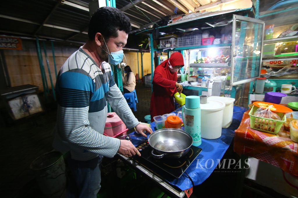 Andi, pedagang, menggunakan kompor induksi untuk berjualan di Kuliner Pintar Taman Blambangan, Banyuwangi, Selasa (24/2/2021). Pemanfaatan kompor induksi membuat pedagang bisa menghemat hingga 50 persen dibanding menggunakan kompor berbahan gas. 