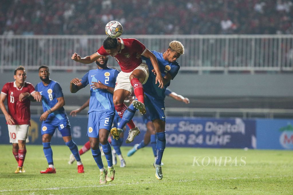 Pemain tim nasional sepak bola Indonesia Rizky Ridho Ramadhani (depan) berusaha menyundul bola saat dibayangi pemain tim Curacao Juninho Gracelio Bacuna (kanan) dalam laga uji coba di Stadion Pakansari, Cibinong, Bogor, Jawa Barat, Selasa (27/9/2022). 
