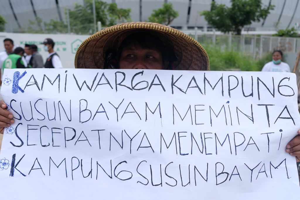 Warga membawa poster tuntutan kepada pihak PT Jakarta Propertindo (JakPro) di depan Stadion Jakarta International Stadium (JIS), Jakarta Utara, Senin (21/11/2022). 