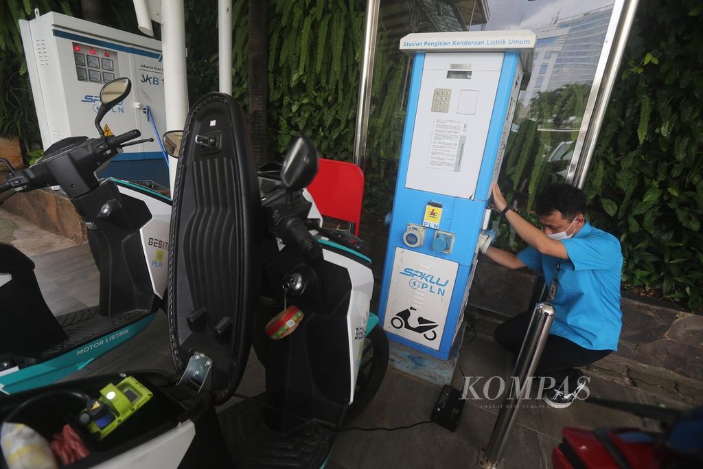  Petugas mengisi daya motor listrik di stasiun pengisian kendaraan listrik umum (SPKLU) di halaman Kantor PLN Distribusi Jakarta Raya, Jakarta, Senin (22/11/2021). Saat ini PLN telah memiliki 47 unit SPKLU yang beroperasi dan hingga akhir tahun akan ada 67 SPKLU yang beroperasi. Infrastruktur itu diperlukan untuk mendukung percepatan pengembangan kendaraan bermotor listrik berbasis baterai.