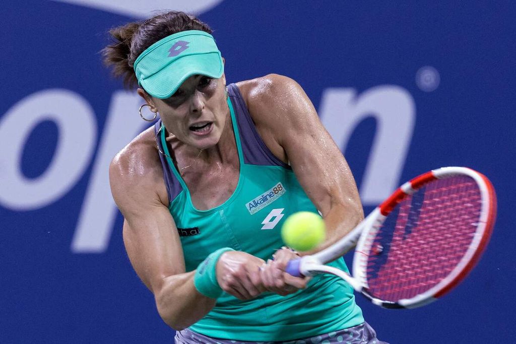 Petenis Perancis Alize Cornet memukul bola ke arah petenis Inggris Emma Raducanu pada pertandingan babak pertama AS Terbuka di Stadion Louis Armstrong, Pusat Tenis Nasional Billie Jean King, Flushing Meadows, New York, Selasa (30/8/2022) waktu setempat atau Rabu pagi WIB. Cornet mengalahkan Raducanu, 6-3, 6-3. 