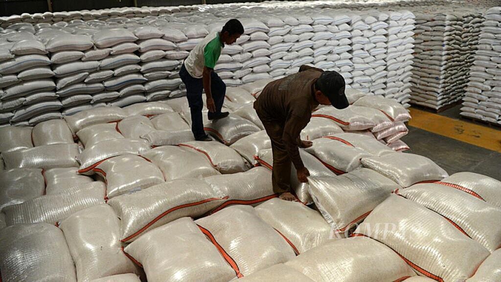 Pekerja menata karung beras yang berada di dalam Gudang Bulog Mangkang, Kota Semarang, Jawa Tengah, Kamis (27/6/2019).