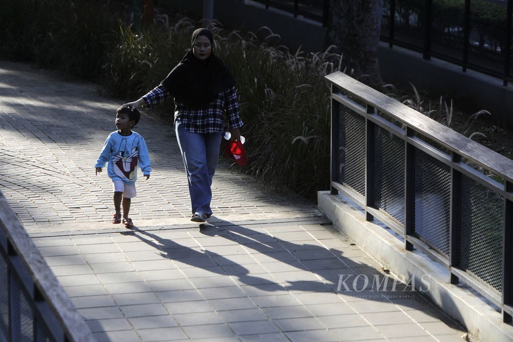 Perempuan bersama anak kecil sedang menikmati suasana Tebet Eco Park, Jakarta Selatan, Kamis (21/3/2024).  