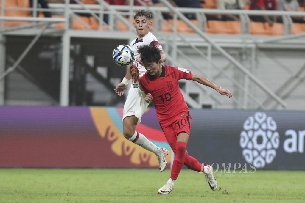 Pemain Korea Selatan, KJin Tae-ho (kanan), berebut bola dengan pemain Amerika Serikat, David Vazques, saat berlaga di babak penyisihan Grup E Piala Dunia U-17 2023 di Stadion Internasional Jakarta (JIS), Minggu (12/11/2023). Korsel kalah 1-3.