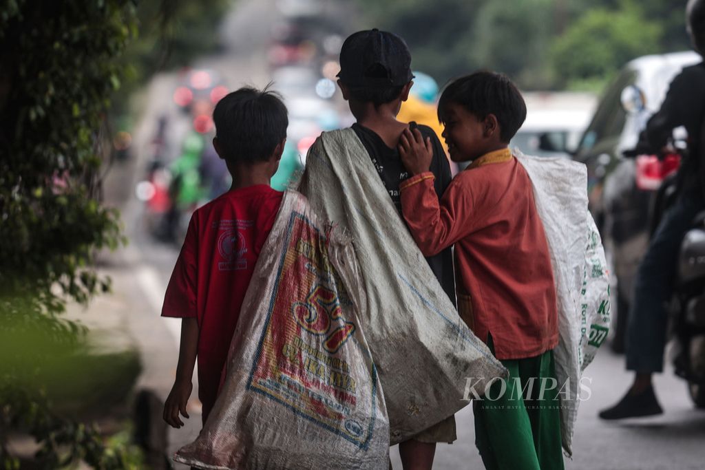 Alief, Rangga, dan Goran (kiri ke kanan) memulung barang bekas di sepanjang Jalan Raya Puspiptek, Buaran, Tangerang Selatan, Banten, Rabu (29/3/2023). Dari bertiga, hanya Rangga yang mengenyam pendidikan di sebuah sekolah dasar. Di balik keberhasilan pemerintah meningkatkan kesejahteraan masyarakat, jutaan anak masih hidup dalam kemiskinan. BPS pada Maret 2022 merilis angka kemiskinan di Indonesia sebesar 9,54 persen. Turun 0,17 persen poin ketimbang September 2021. Berdasarkan kelompok umur, ternyata ada 11,8 persen penduduk berumur di bawah 18 tahun yang hidup di bawah garis kemiskinan nasional (Rp 16.815,63 per hari).