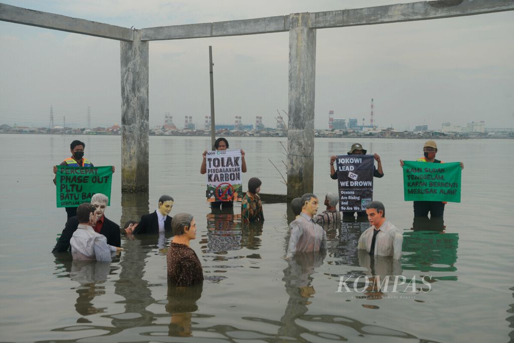 Aktivis Wahana Lingkungan Hidup Indonesia (Walhi) Jawa Tengah beserta komunitas membentangkan poster berisi kritikan pada pemerintah tentang persoalan lingkungan di Tambakrejo, Kota Semarang, Jawa Tengah, Jumat (5/11/2021). Kampanye lingkungan ini menuntut pemerintah dalam membuat kebijakan yang mendukung kelestarian lingkungan dari aspek ekonomi, sosial, hukum dan politik.