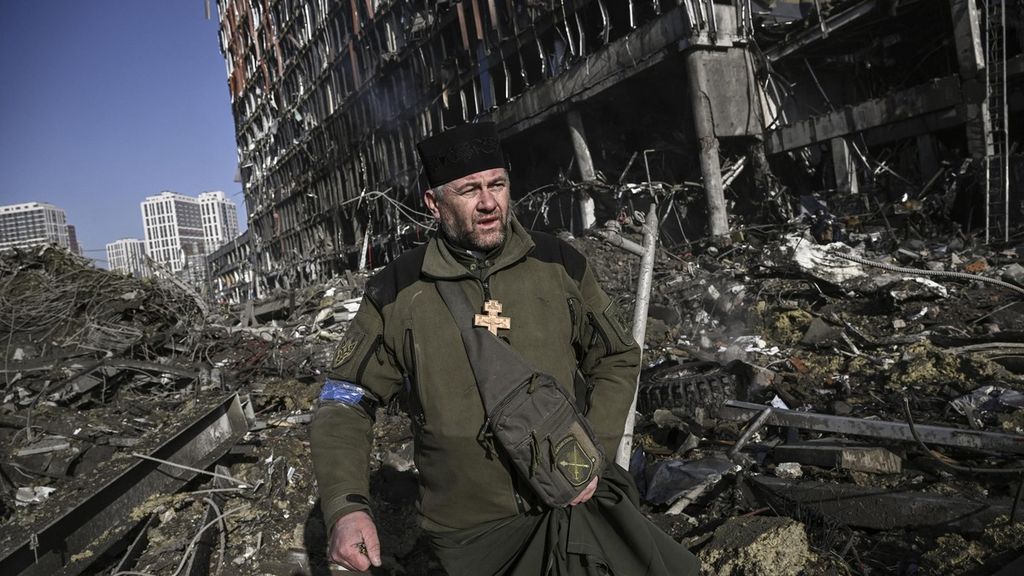 Tentara Ukraina, Mikola Madenski, berjalan melewati puing-puing di luar pusat perbelanjaan Retroville yang hancur setelah serangan Rusia di ibu kota Ukraina, Kiev (21/3/2022). Invasi Rusia ke Ukrania sudah berlangsung lebih dari sebulan. 