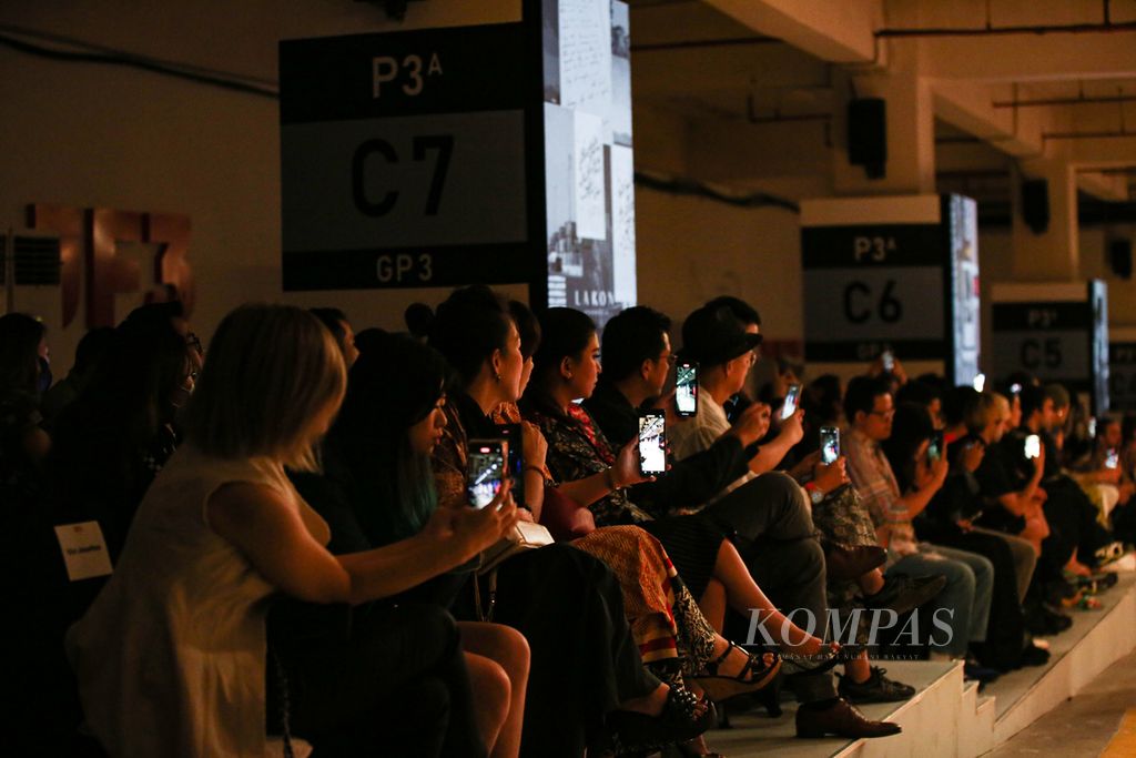 Tamu undangan mengabadikan peragaan busana dari LAKON Indonesia pada penutupan perhelatan JF3 2023 di Sumarecon Mall Kelapa Gading, Jakarta, Rabu (26/7/2023) malam. JF3 kali ini mengusung tema #JF3PowerToEmpower yang bertujuan mendorong pemberdayaan industri mode Indonesia secara berkelanjutan.