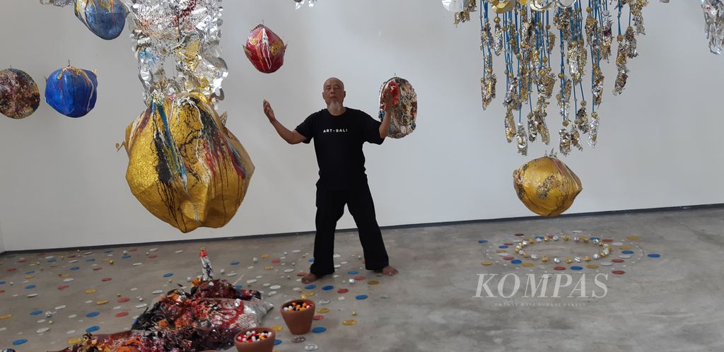 Perupa Nyoman Erawan di tengah karya instalasinya dalam pameran tunggal Rekakara Pangurip Gumi di ruang seni Sangkring, Nitiprayan, Bantul, Yogyakarta, menjelang pembukaan, Selasa (5/7/2022). Pameran berlangsung hingga 15 September 2022.